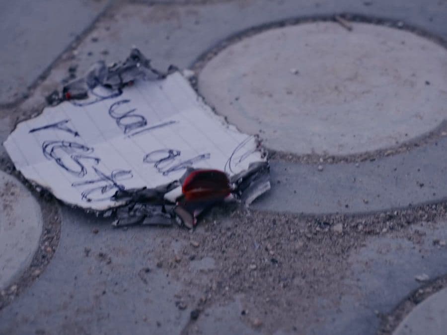 Papel quemado del videoclip, con «igual al resto» escrito a mano